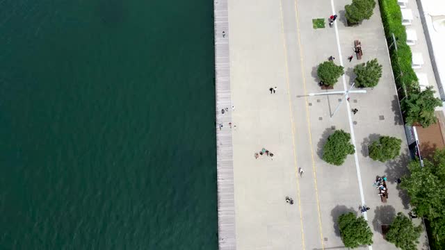 鸟瞰图城市海岸，公园与人，道路与汽车在希腊塞萨洛尼基，移动和前进的无人机。视频下载
