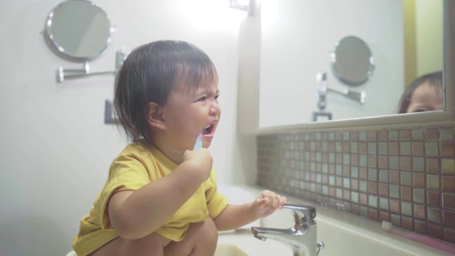 一个亚洲女婴在浴室里刷牙视频素材