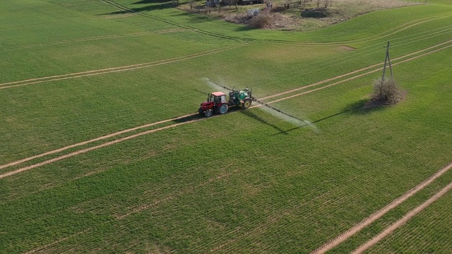 农用拖拉机用喷雾器喷施春小麦田、空中喷雾视频素材