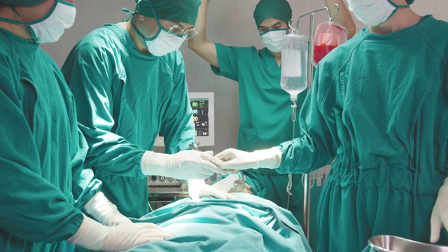 一群亚洲医生、护士和外科医生手中拿着医疗器械，看着病人并做手术。团队合作，医疗保健和医疗理念。外科医生会说话并使用器械。视频素材