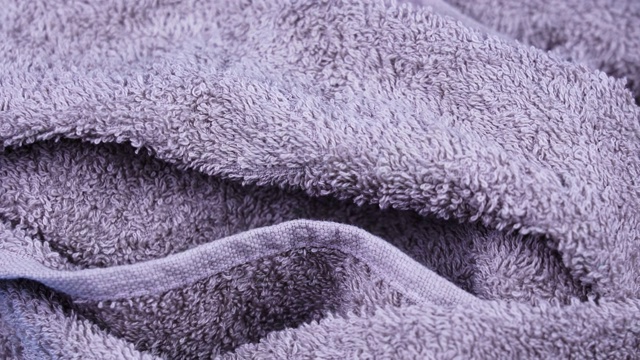 大皱巴巴的紫色毛巾布毛巾躺着并旋转着视频素材