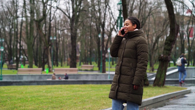 积极的黑人女孩在公园打电话在阴沉的天气视频下载