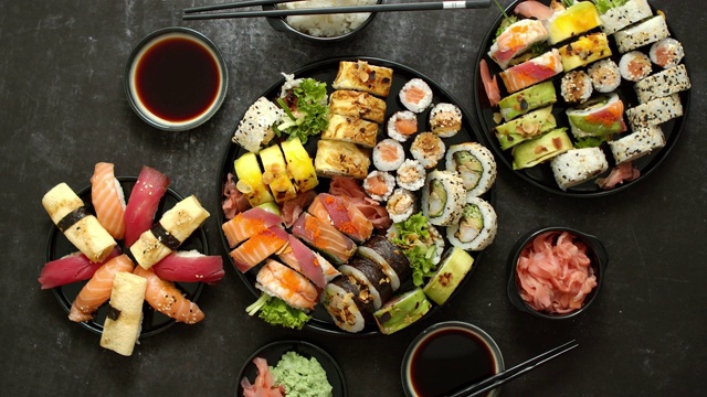 亚洲食品节。菜单寿司与手握寿司，maki，浦卷寿司在黑色盘子。各种寿司视频素材
