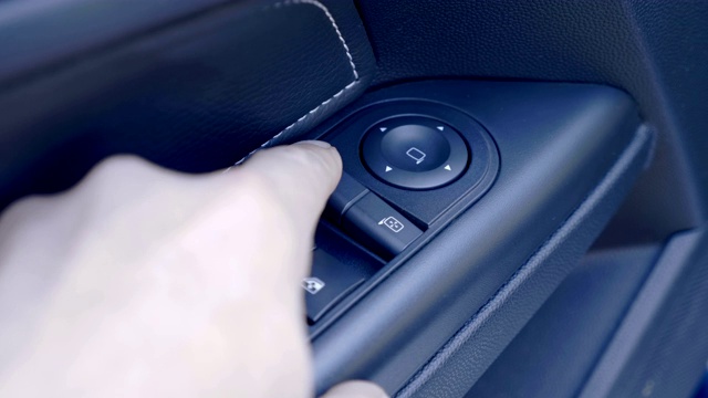 司机的手按下车门扶手上的按键，调整后视镜视频素材