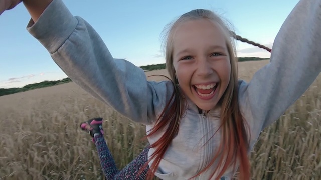 有趣快乐的女儿在她父亲的怀抱在夏天的傍晚农村的田野视频素材