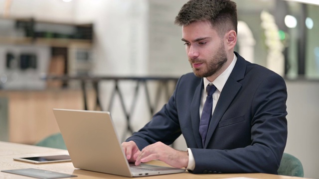 努力工作的年轻商人在办公室笔记本电脑背痛视频素材