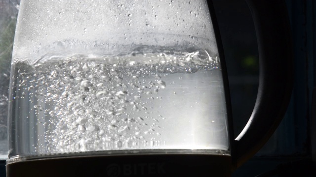透明的旧水壶中沸腾的水的气泡视频素材