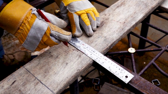 建筑工人用卷尺测量木板，用铅笔写字，男性手的近处测量木地板，建筑行业，家务自己做视频下载