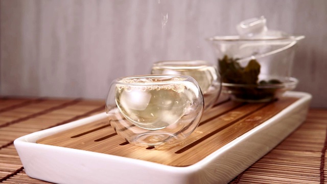 中国绿茶从玻璃茶壶到一个小杯子视频素材