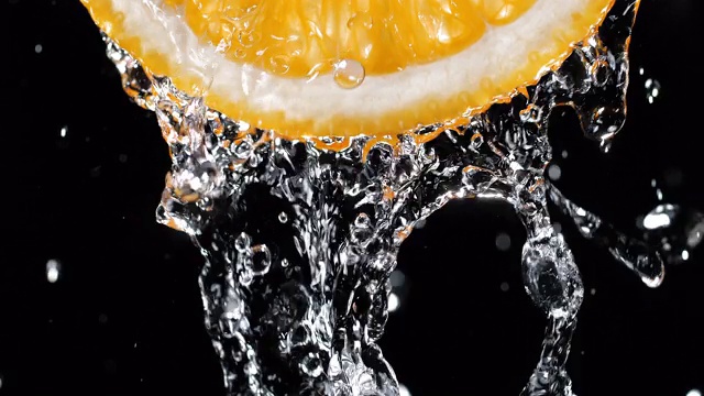 水倒在背光橘汁片上视频素材