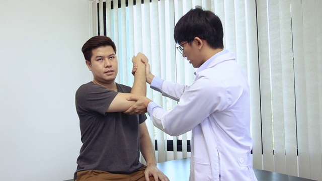 亚洲理疗师检查接受过矫形康复治疗的患者的肘部。视频素材