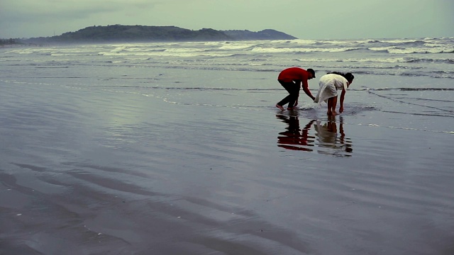 年轻夫妇在海岸线附近玩耍视频素材