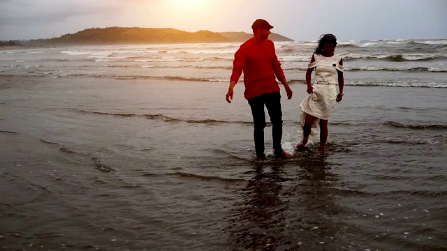 一对情侣在海滩上散步视频素材