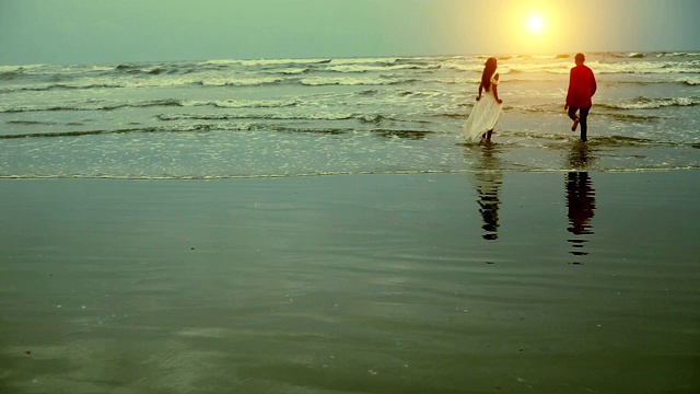 一对夫妇在日落时间享受夏天的海滩视频素材