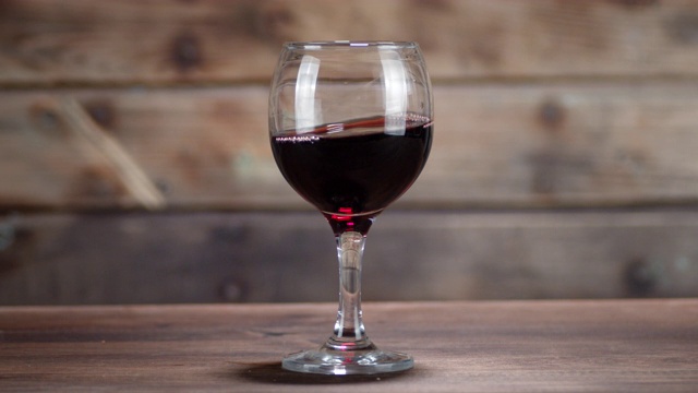 红酒在桌子上的玻璃杯中移动。视频下载