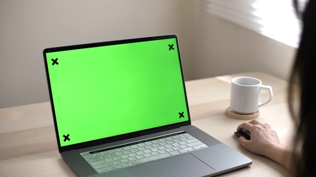 亚洲女人看着绿色屏幕的笔记本电脑视频素材