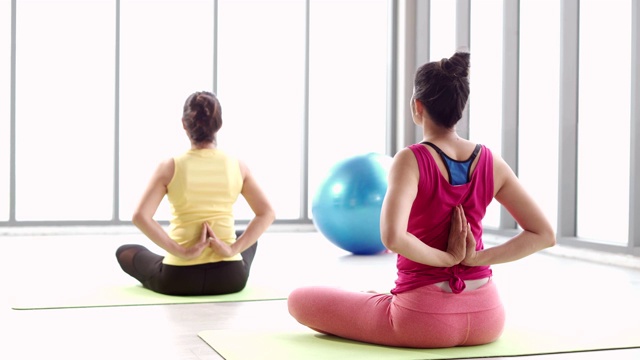 一名中年妇女在客厅瑜伽课上进行冥想练习时放松视频素材