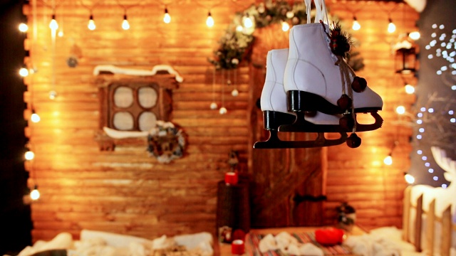 白色的女滑冰鞋在一个木制的仙女房子的背景。圣诞和新年的主题视频下载