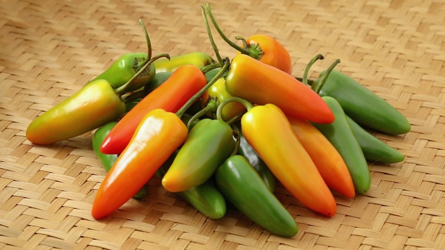 新鲜采摘的五颜六色的墨西哥辣椒放在茅草表面视频素材
