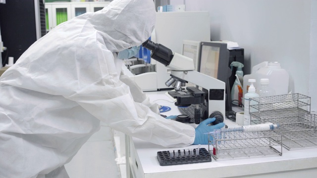 科学家们在无菌室里减少，试试显微镜。检查感染用显微镜观察血小板实验血样。视频素材
