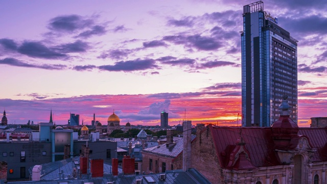 史诗般的紫色日落在里加市与圆顶大教堂，老城，丽笙酒店和耶稣诞生大教堂在地平线上。视频素材