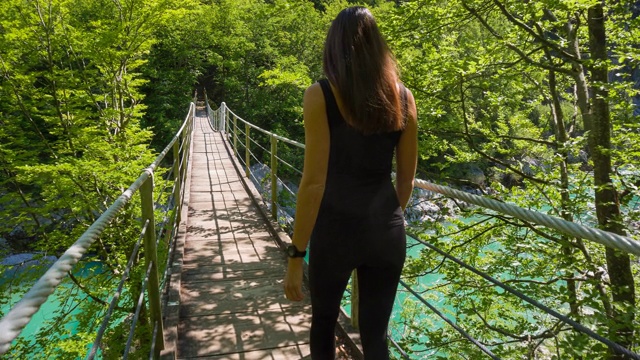 一个年轻女子走在木桥上视频素材