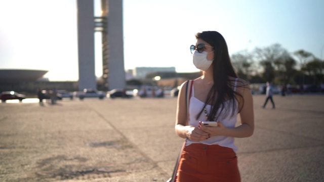 年轻的女旅行者在巴西行走，戴着面具视频下载
