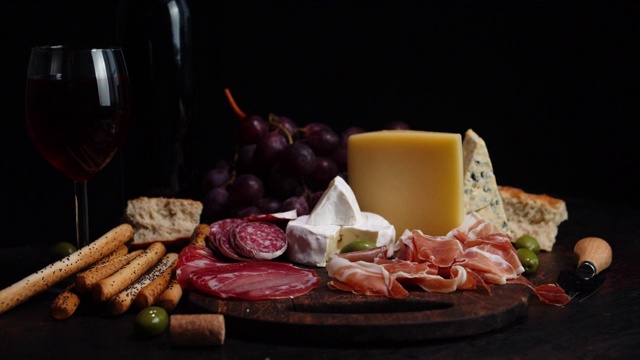 开胃菜、奶酪和葡萄酒在桌上缓缓旋转。视频下载