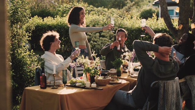 手持式的照片，欢快的朋友在花园派对上敬酒视频素材