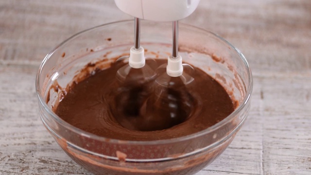 用于烘焙蛋糕、饼干、糕点的巧克力面团或面糊。将巧克力放入碗中搅拌视频素材