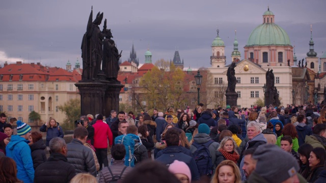 游客在布拉格历史古城查尔斯桥上散步，以哥特式雕像和海鸥为背景自拍视频下载