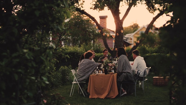社交聚会时，男女朋友坐在餐桌前互相敬酒的慢镜头视频素材