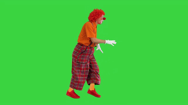 有趣的小丑行走和回顾有时在绿色屏幕，色度键视频素材
