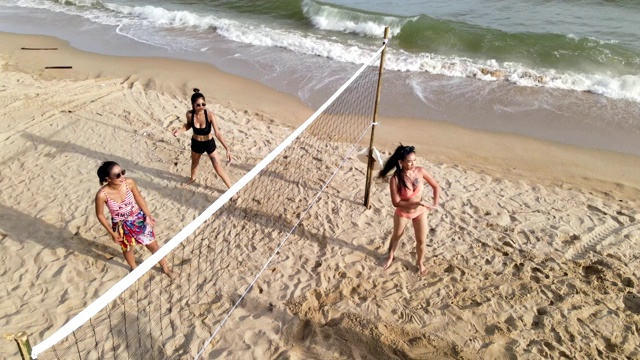 一群朋友晚上在沙滩上玩沙滩排球，开心放松，玩得很开心。视频下载