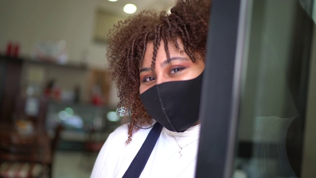 一名女企业主戴着口罩在咖啡店里的肖像视频素材