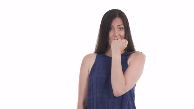 一个白人女人咬着拳头表示绝望和担忧。在白色背景上隔离视频素材