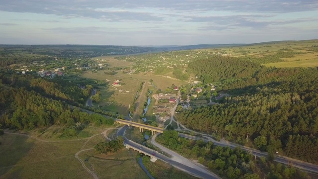 鸟瞰图高速公路通过绿色的田野在一个夏天的阳光灿烂的一天。在草地和乡村田野之间有沥青高速公路的4k镜头景观。无人机拍摄视频。视频素材
