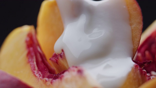 酸奶倒在新鲜的桃子片上。极端特写镜头视频下载