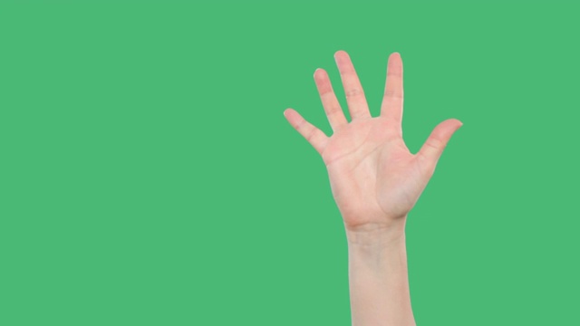 在绿色背景上举起手的人的裁剪镜头视频素材