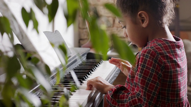 MCU，稳定手持-年轻的混合种族女孩弹钢琴视频下载