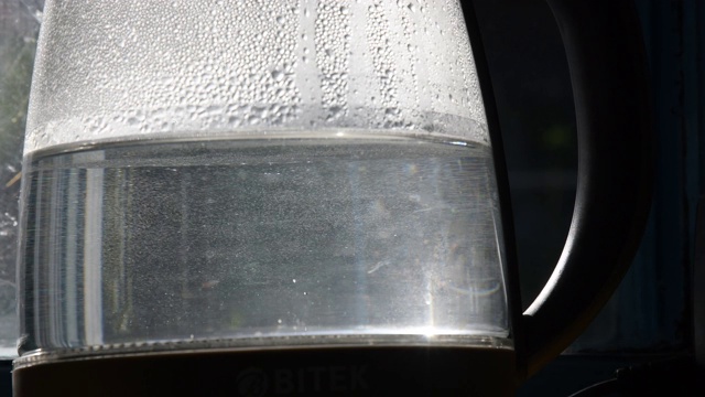 特写未清除的沸水在旧透明水壶与水垢视频素材