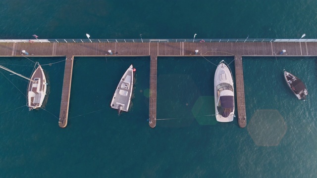 鸟瞰港口，帆船和摩托艇停泊在码头上视频素材