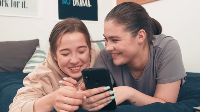 笑着看智能手机的快乐女性朋友视频素材
