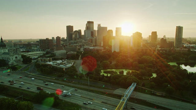黎明时分，阳光在明尼阿波利斯市中心的建筑物之间洒向洛林公园和高速公路视频素材