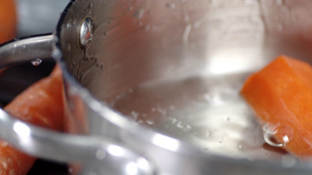 将新鲜胡萝卜与水一起倒入平底锅中。视频下载