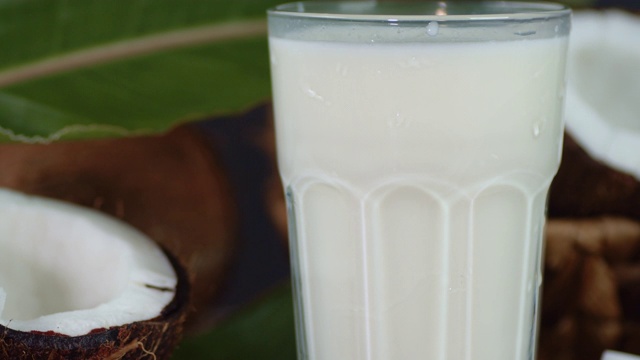 椰奶在玻璃杯中缓慢旋转。视频下载