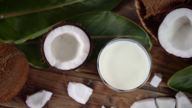 椰奶在一杯半新鲜椰子中慢慢旋转。视频下载