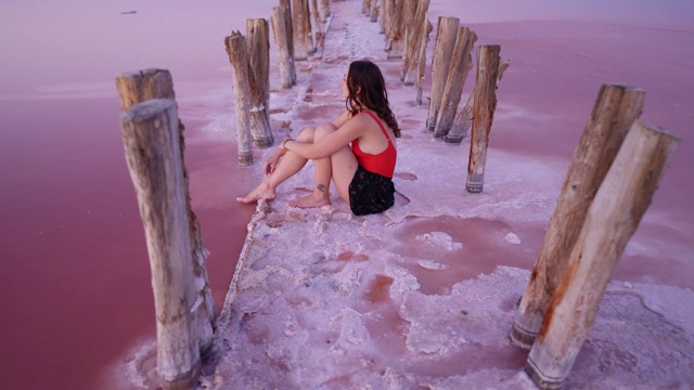 坐在乌克兰粉色盐湖上的女人视频素材