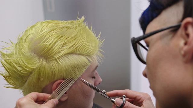 理发师用梳子和剪刀为顾客理发-慢镜头视频下载