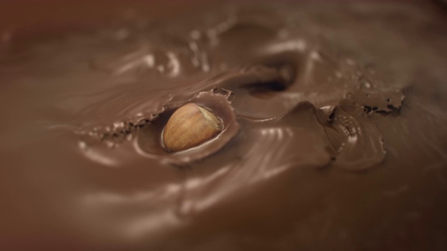 4K超级慢动作，榛子溅入液态牛奶巧克力视频素材